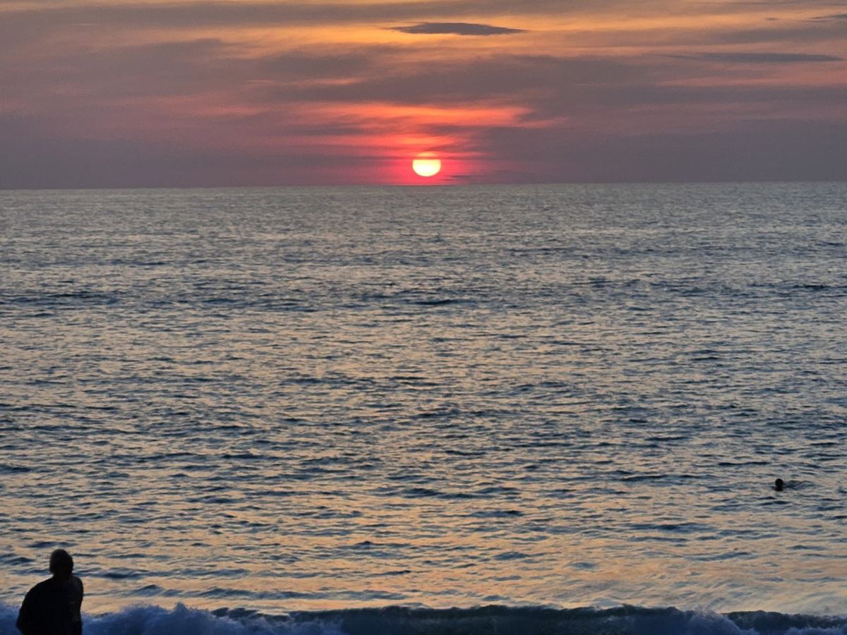 Sunset over the sea at Mai Khao beach
